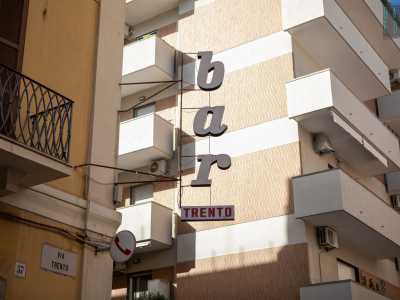 � affiancata dal simbolo del telefono, tipico degli esercizi commerciali che un tempo, quando non esistevano ancora i cellulari, ospitavano un telefono pubblico